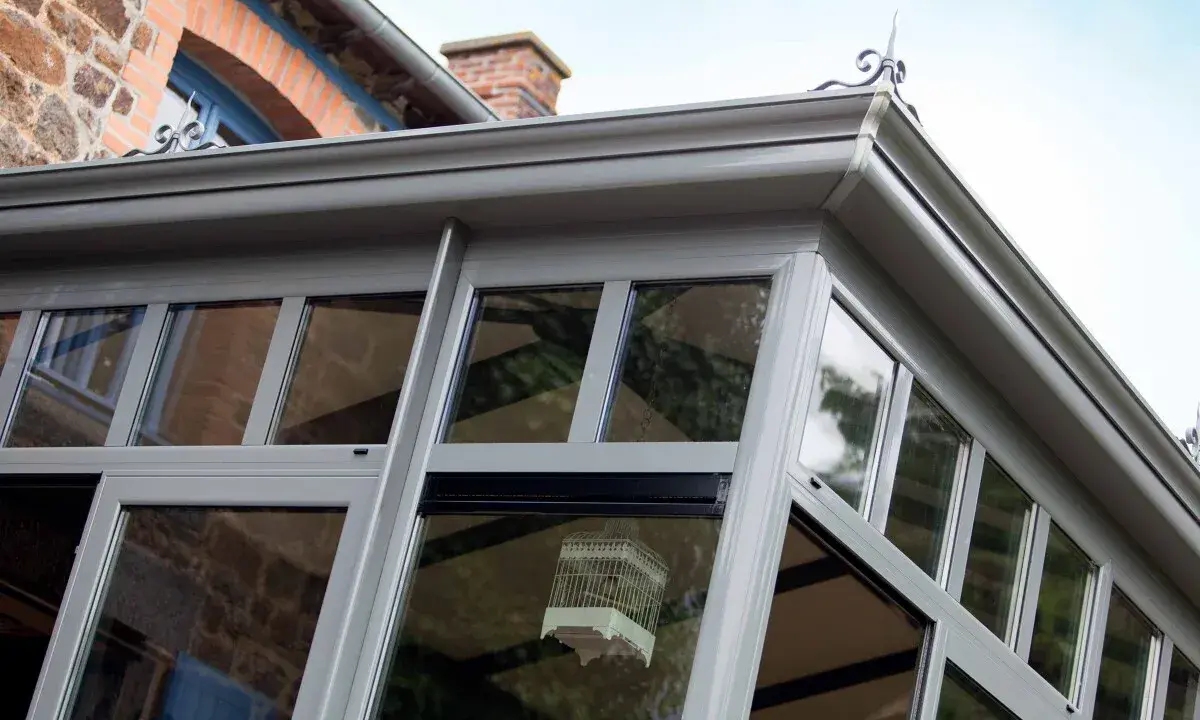 Une véranda moderne, idéale pour un projet d'extension permis de construire. Une cage décorative est suspendue à l'intérieur.