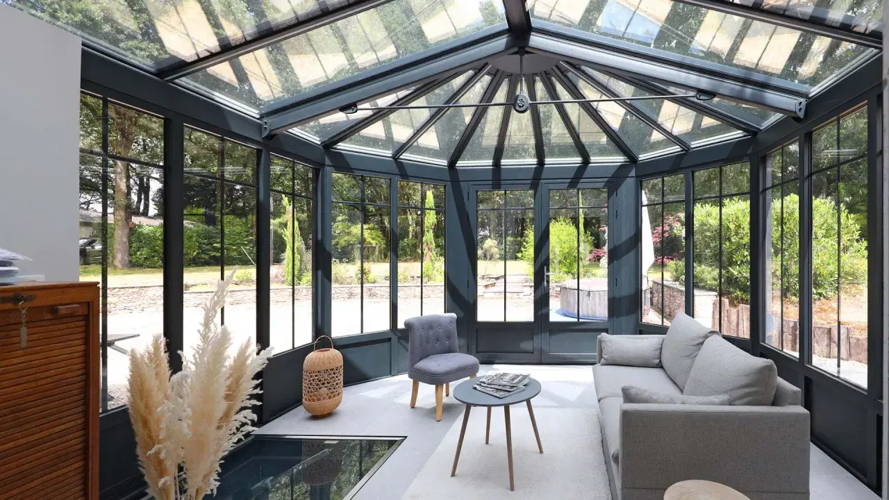 Une extension veranda moderne baignée de lumière, avec un salon confortable et une vue imprenable sur le jardin verdoyant.