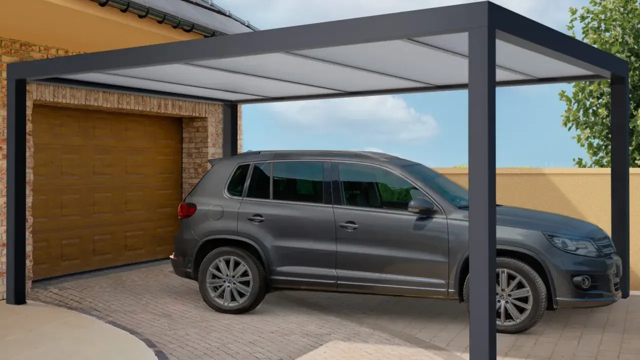 Une voiture grise est garée sous un tva carport moderne, à côté d'un garage.