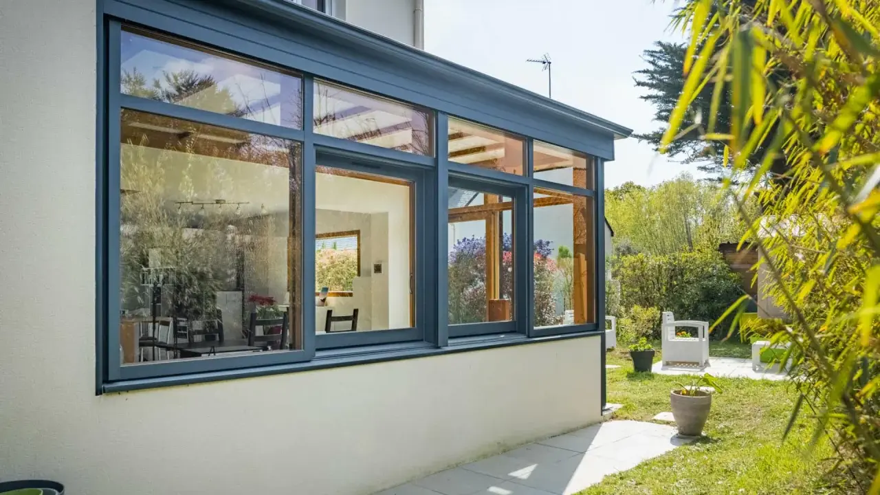 Belle extension cuisine sur jardin, avec de grandes baies vitrées offrant une vue imprenable sur la verdure et le soleil.