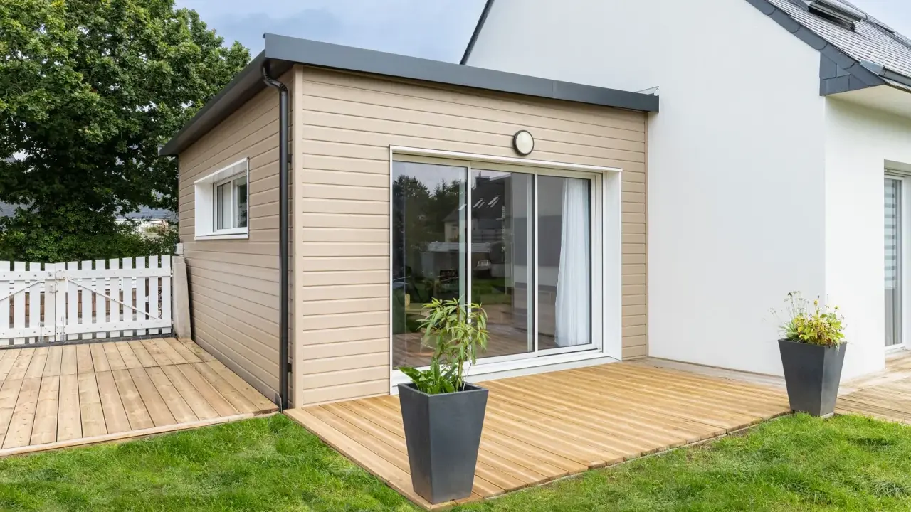 Une extension bois moderne avec terrasse en bois, créant un espace de vie extérieur agréable.