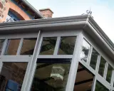Une véranda moderne, idéale pour un projet d'extension permis de construire. Une cage décorative est suspendue à l'intérieur.