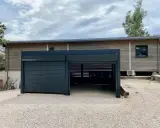 Abri voiture moderne avec un volet roulant fermé et une partie ouverte. Faut-il un permis de construire pour un abri voiture ouvert ?