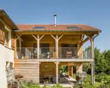 Extension en bois sur pilotis, avec balcon et terrasse aménagée. Une belle intégration architecturale.