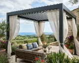 Un salon extérieur confortable sous une pergola moderne, offrant une vue imprenable sur la mer. Ces vérandas bioclimatiques invitent à la détente.