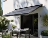 Store banne gris protégeant une terrasse aménagée, créant un espace convivial à distance des voisins.