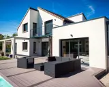 Une maison moderne avec une extension spacieuse, une terrasse en bois et une piscine. L'ensemble évoque une transformation réussie : extension maison avant après.