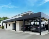 Deux voitures noires garées sous un carport moderne. Le propriétaire a décidé de fermer un carport sans autorisation, créant un espace de stationnement élégant.