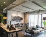 Un agrandissement salon moderne avec un canapé en cuir, une table à manger, une grande œuvre d'art abstraite et des plantes vertes.