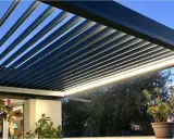 Pergola bioclimatique moderne avec lames parallèles, éclairage LED intégré, créant une ambiance douce au crépuscule.