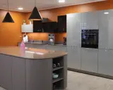 Cuisine moderne avec îlot central et armoires grises. Une extension cuisine maison idéale pour un espace fonctionnel et élégant.