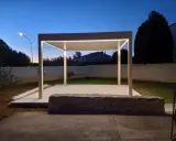 Une élégante pose pergola avec éclairage LED intégré, illuminant le jardin au crépuscule.