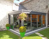 Veranda moderne avec vue sur jardin. Pensez à la taxe d'aménagement veranda pour ce projet d'agrandissement.