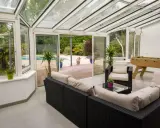 Vaste veranda 50m2 avec salon, baby-foot et vue sur piscine. Idéal pour se détendre et s'amuser en famille.