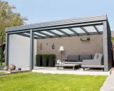 Une pergola adossée ou autoportée moderne avec salon extérieur, chauffage et plantes.