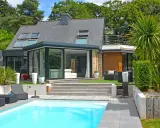 Maison moderne avec véranda et piscine. Pensez à comment déclarer une véranda aux impôts pour optimiser votre situation.