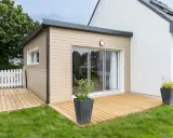 Une extension bois moderne avec terrasse en bois, créant un espace de vie extérieur agréable.