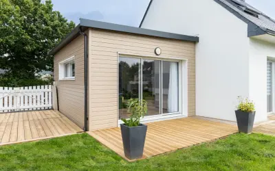 Une extension bois moderne avec terrasse en bois, créant un espace de vie extérieur agréable.