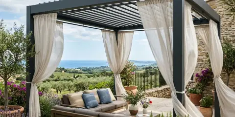 Un salon extérieur confortable sous une pergola moderne, offrant une vue imprenable sur la mer. Ces vérandas bioclimatiques invitent à la détente.