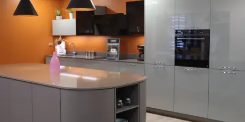 Cuisine moderne avec îlot central et armoires grises. Une extension cuisine maison idéale pour un espace fonctionnel et élégant.
