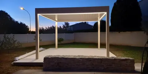 Une élégante pose pergola avec éclairage LED intégré, illuminant le jardin au crépuscule.