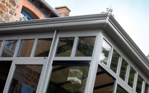 Une véranda moderne, idéale pour un projet d'extension permis de construire. Une cage décorative est suspendue à l'intérieur.