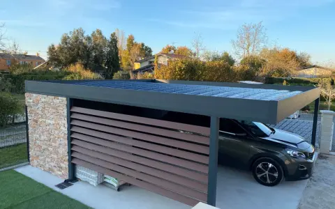 Un carport moderne avec un toit plat, idéal pour comment couvrir un carport toit plat. Une voiture y est garée.