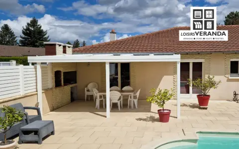 Un fabricant de pergolas a installé cette belle terrasse avec mobilier de jardin, barbecue et piscine.