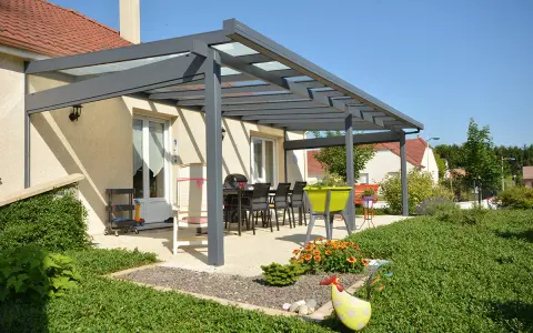 Superbe pergola Veranco avec toit vitré, aménagée pour les repas d'été. Avis très positif sur cette extension de maison.