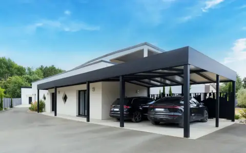 Deux voitures noires garées sous un carport moderne. Le propriétaire a décidé de fermer un carport sans autorisation, créant un espace de stationnement élégant.