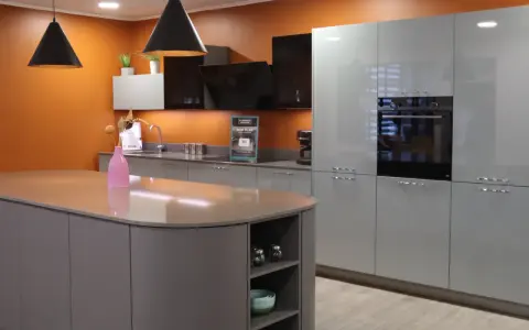 Cuisine moderne avec îlot central et armoires grises. Une extension cuisine maison idéale pour un espace fonctionnel et élégant.