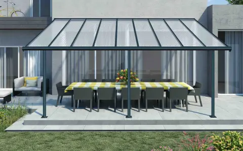 Une pergola canisse protège une table dressée et des fauteuils de la pluie, créant un espace extérieur accueillant.