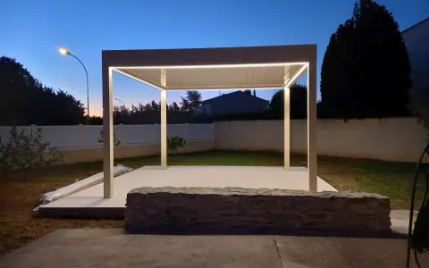 Une élégante pose pergola avec éclairage LED intégré, illuminant le jardin au crépuscule.