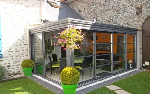 Veranda moderne avec vue sur jardin. Pensez à la taxe d'aménagement veranda pour ce projet d'agrandissement.
