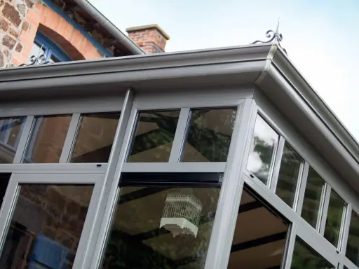 Une véranda moderne, idéale pour un projet d'extension permis de construire. Une cage décorative est suspendue à l'intérieur.