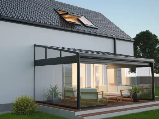 Une élégante veranda hexagonale en verre et métal, avec un salon confortable, s'intègre parfaitement à une maison moderne.