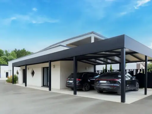 Deux voitures noires garées sous un carport moderne. Le propriétaire a décidé de fermer un carport sans autorisation, créant un espace de stationnement élégant.