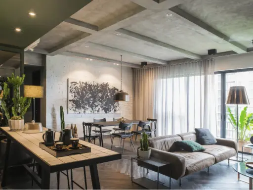 Un agrandissement salon moderne avec un canapé en cuir, une table à manger, une grande œuvre d'art abstraite et des plantes vertes.