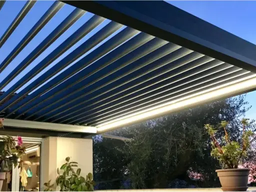 Pergola bioclimatique moderne avec lames parallèles, éclairage LED intégré, créant une ambiance douce au crépuscule.