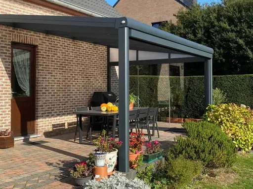 Terrasse avec pergola moderne, table et chaises. Le calcul prise au vent pergola est essentiel pour sa stabilité.
