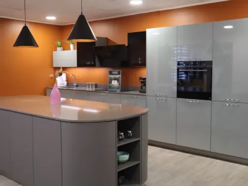 Cuisine moderne avec îlot central et armoires grises. Une extension cuisine maison idéale pour un espace fonctionnel et élégant.