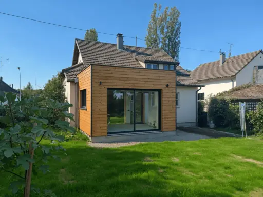 Extension de moins de 20m2 avec permis de construire, ajoutant une pièce lumineuse avec grandes baies vitrées à une maison.