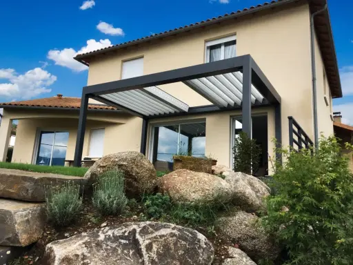 Pergola moderne sur terrasse avec vue sur une maison et un jardin rocheux.