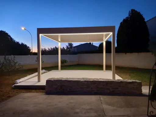 Une élégante pose pergola avec éclairage LED intégré, illuminant le jardin au crépuscule.
