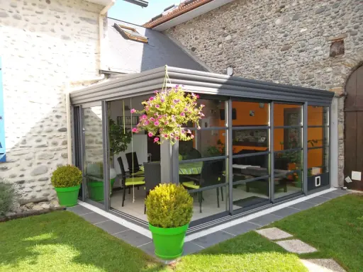 Veranda moderne avec vue sur jardin. Pensez à la taxe d'aménagement veranda pour ce projet d'agrandissement.