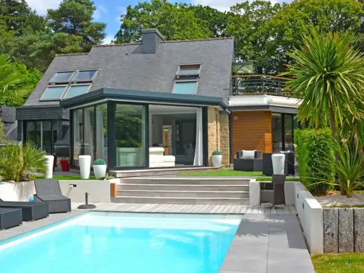 Maison moderne avec véranda et piscine. Pensez à comment déclarer une véranda aux impôts pour optimiser votre situation.