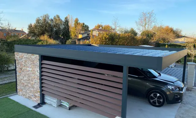 Un carport moderne avec un toit plat, idéal pour comment couvrir un carport toit plat. Une voiture y est garée.