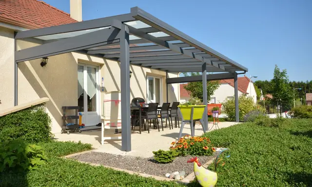 Superbe pergola Veranco avec toit vitré, aménagée pour les repas d'été. Avis très positif sur cette extension de maison.
