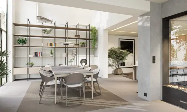 Une salle à manger moderne et lumineuse, avec une grande étagère murale, une table et des chaises, et une cheminée design. Cette **petite extension de maison** est un espace de vie accueillant.