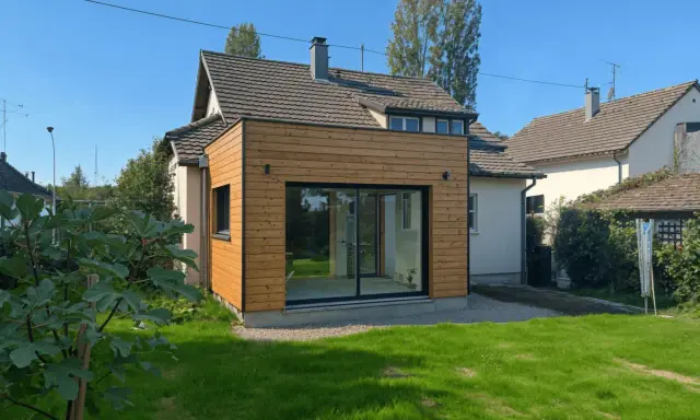 Extension de moins de 20m2 avec permis de construire, ajoutant une pièce lumineuse avec grandes baies vitrées à une maison.